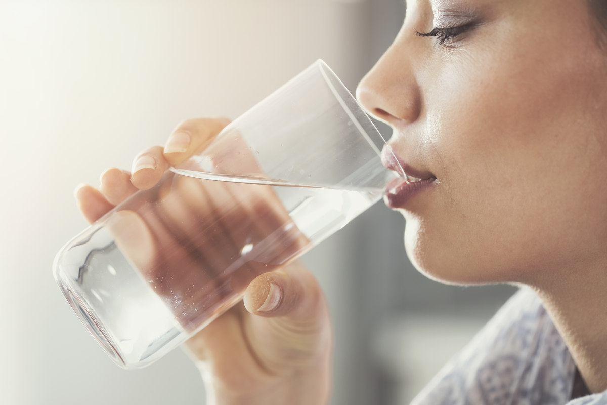 Eine Frau trinkt ein Glas Wasser