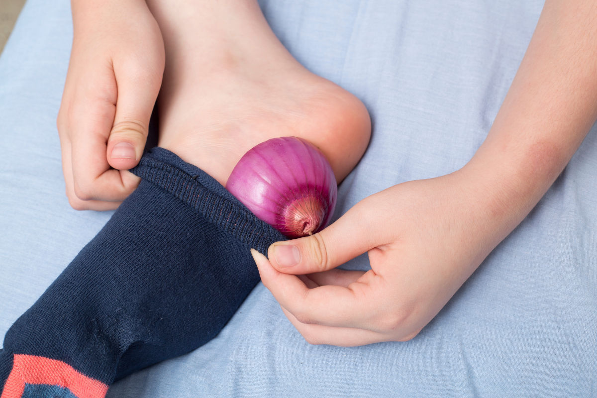 Kind steckt Zwiebel in seine Socke - ein Hausmittel bei Halsschmerzen