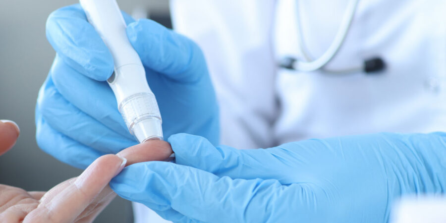 ApothekerIn entnimmt einen Tropfen Blut aus der Fingerkuppe für den Langzeitzucker-Test